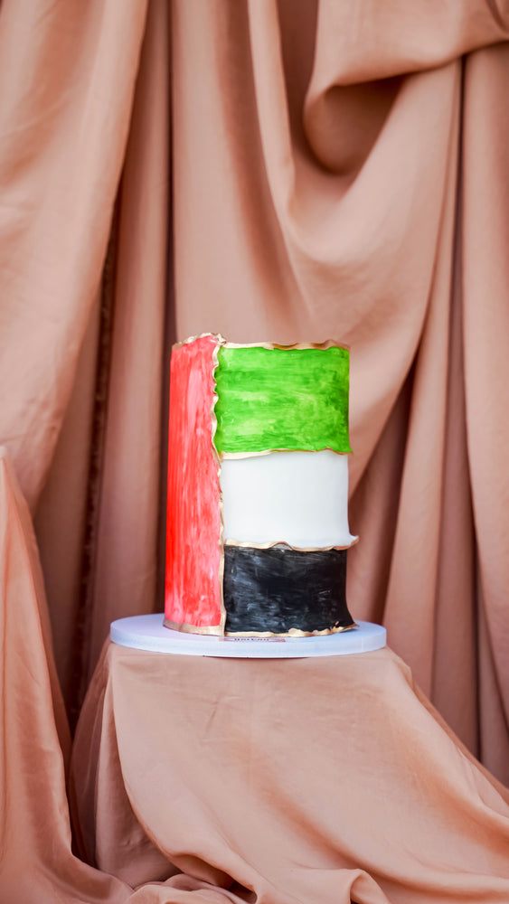 National Day cake UAE in vibrant colors of the UAE flag displayed elegantly on a cake stand
