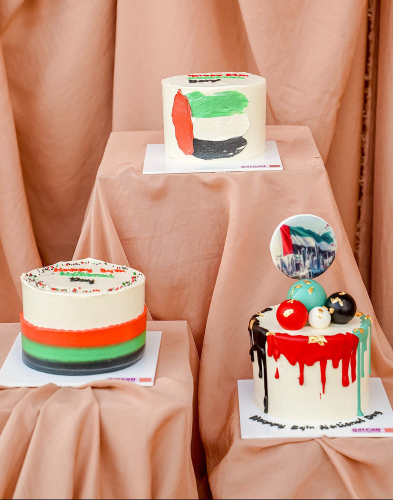 Three vibrant National Day mini cakes decorated in red, green, white, and black for festive celebrations