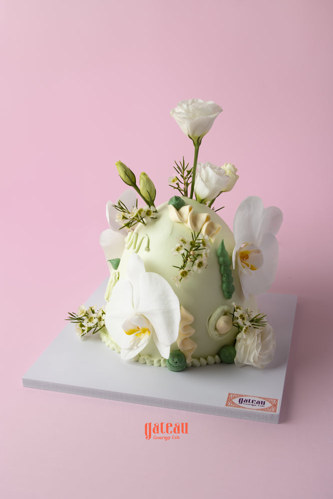 Elegant fresh flowers dome cake decorated with white orchids and green accents from Gateau Gourmet Cafe