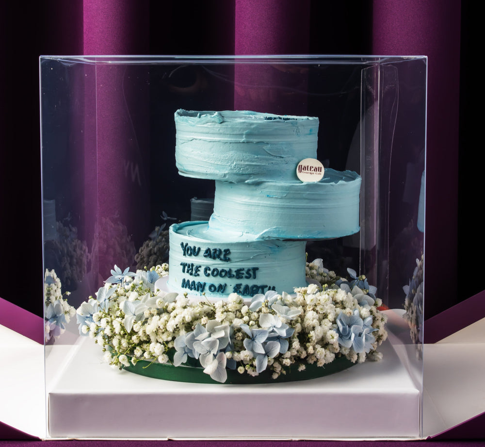 Father's Day floral arrangement cake by Gateau Gourmet Cafe with blue frosting and white flowers