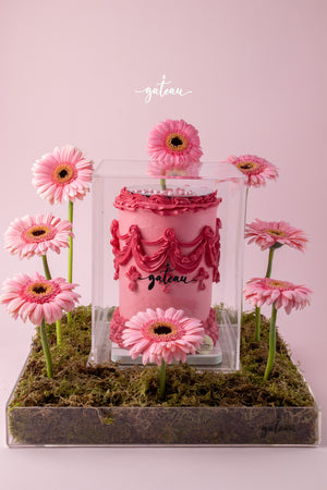 All Pink Victorian Cake with Mirror and Flower Arrangement showcased with pink gerbera daisies