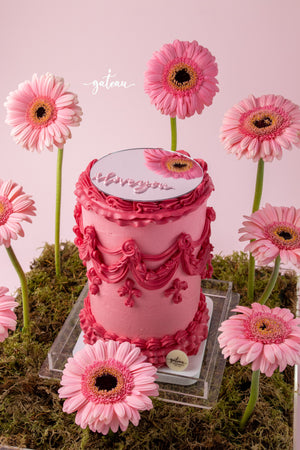 All Pink Victorian Cake with Mirror and Flower Arrangement surrounded by pink gerbera daisies