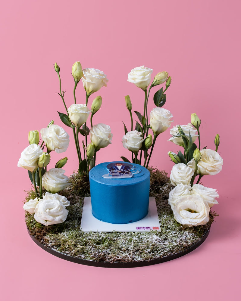 Arabic meme cake by Gateau Gourmet Cafe blue cake surrounded by white flowers on moss base