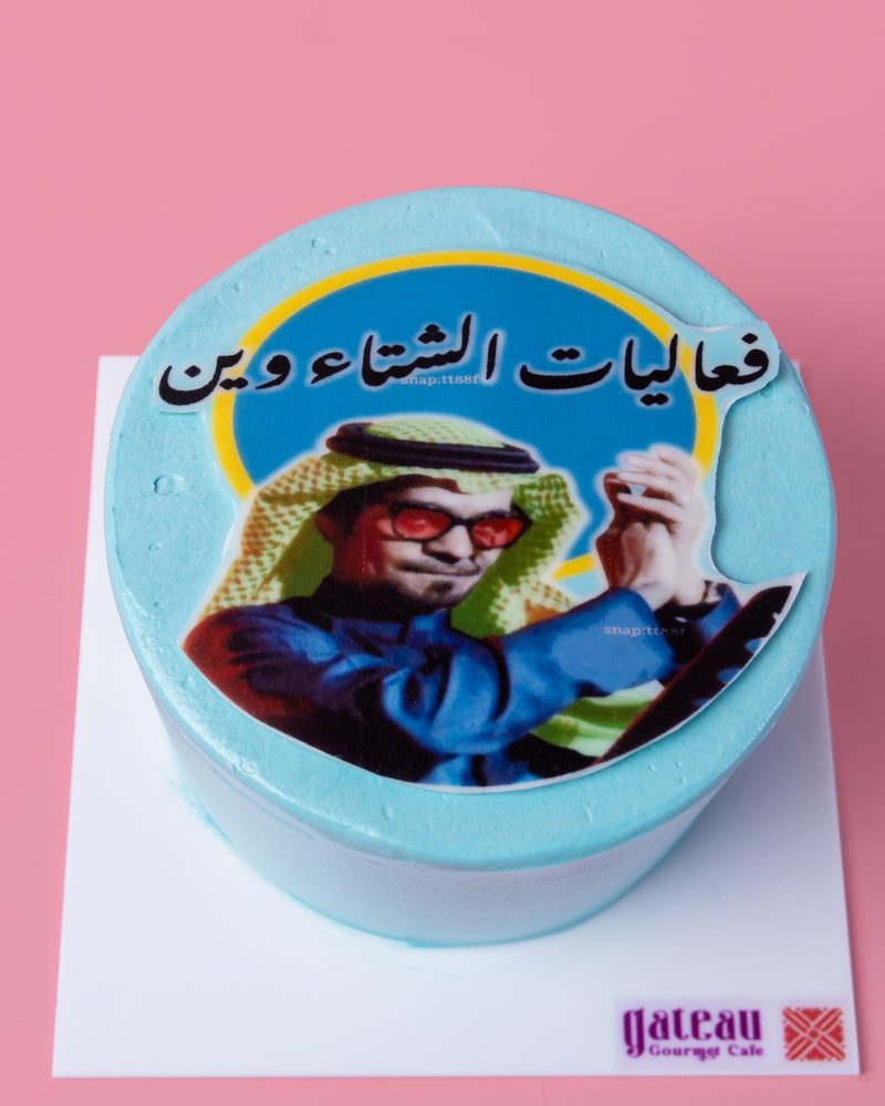 Arabic meme cake with a humorous image and Arabic text on blue frosting from Gateau Gourmet Cafe
