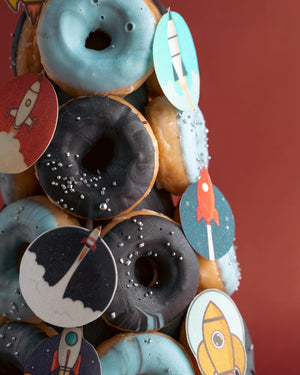 Gateau Gourmet Cafe artisan donut tower with blue and black frosted donuts decorated with rocket-themed toppers
