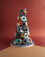 Gateau Gourmet Cafe artisan donut tower with chocolate and blue glazed donuts decorated with rocket toppers