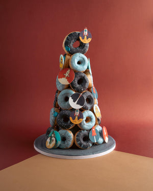 Gateau Gourmet Cafe artisan donut tower with chocolate and blue glazed donuts decorated with rocket toppers
