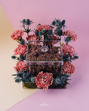 Gateau Gourmet Cafe artisan nutty chocolate pieces in a clear box surrounded by pink and blue flowers