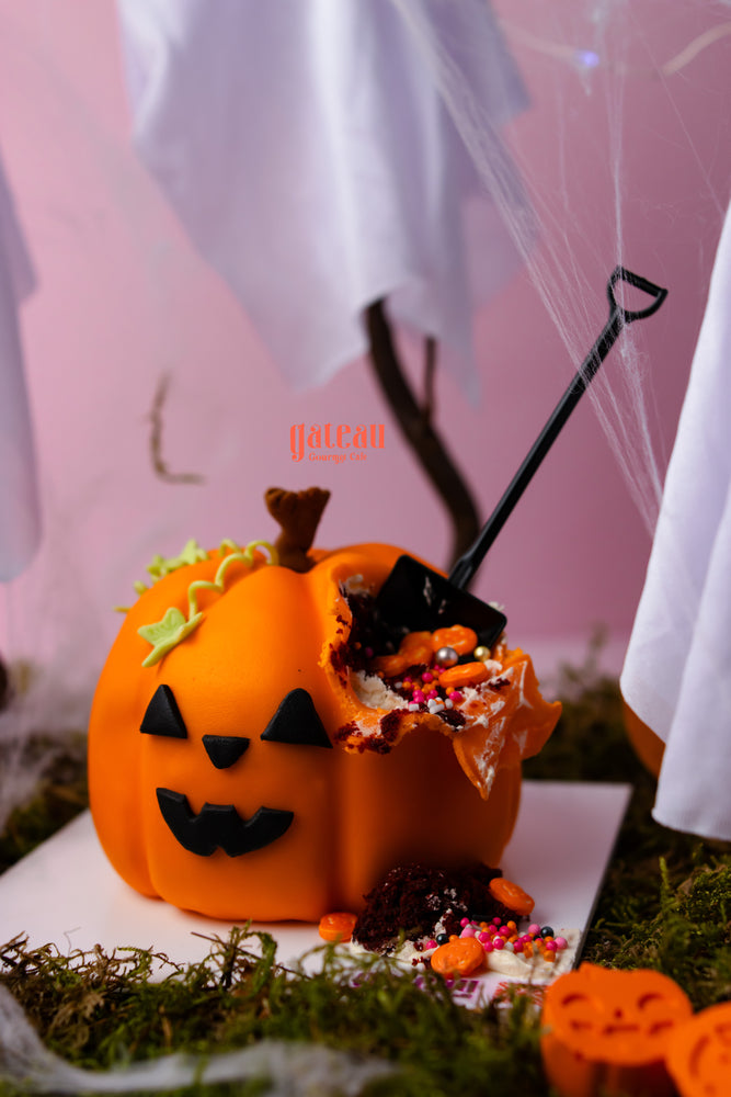 Baby pumpkin cake with spooky decoration featuring a jack-o'-lantern design and candy toppings