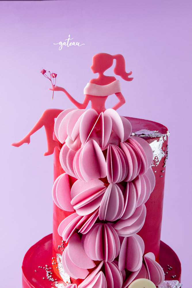 Barbie birthday cake with pink paper dress decoration and red fondant base by Gateau Gourmet Cafe