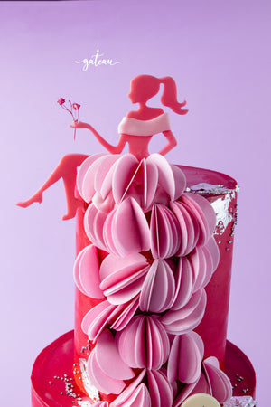 Barbie birthday cake with pink paper dress decoration and red fondant base by Gateau Gourmet Cafe