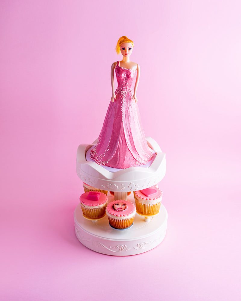 Barbie birthday cake with pink dress design and matching pink cupcakes on a white stand