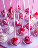 Pink and white barbie cake pops delivery decorated with sprinkles and bows on sticks