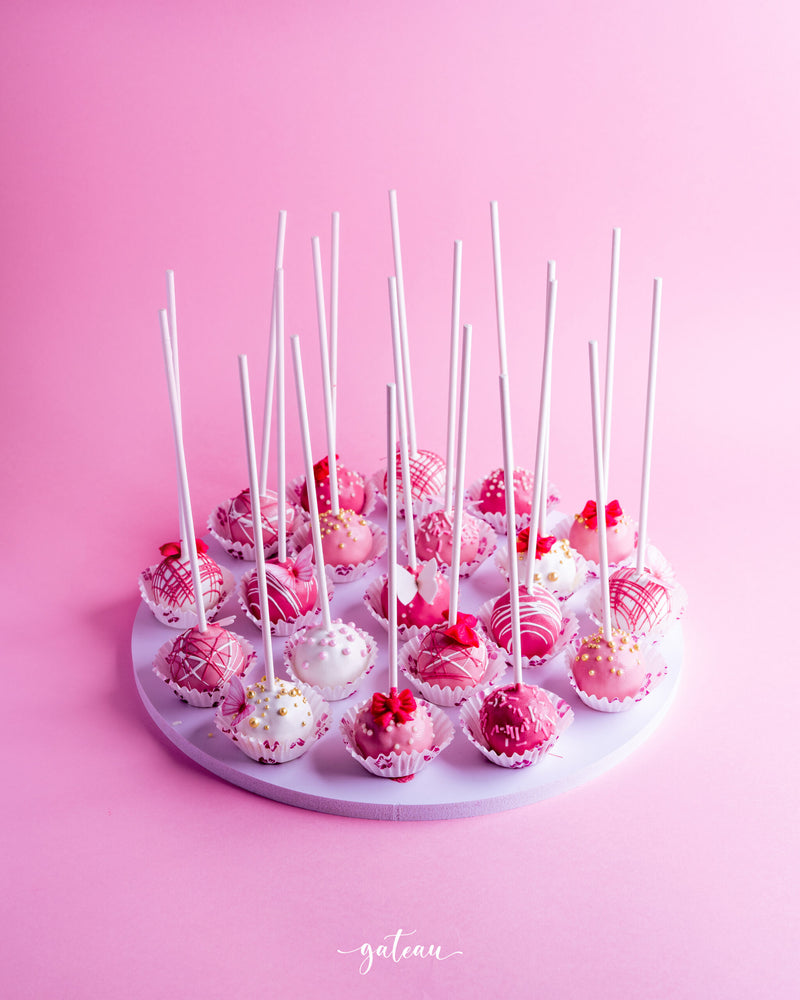 Gateau Gourmet Cafe pink and white cake pops arranged on a white round tray for barbie cake pops delivery
