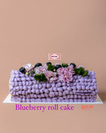 Blueberry Swiss roll cake gift from Gateau Gourmet Cafe decorated with purple frosting and fresh flowers