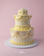 Bride to Be custom cake by Gateau Gourmet Cafe three-tier white cake with elegant floral and swirl decorations