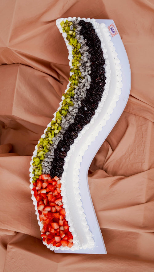 Curve sheet cake decorated with fresh fruits and cream from Gateau Gourmet Cafe