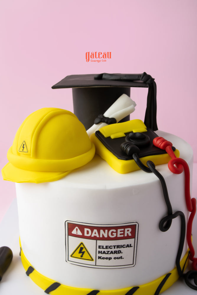 Electrical engineering cake with yellow hard hats and caution signs for celebrating engineering achievements