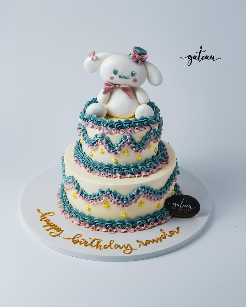 Two-tiered cake featuring a cute bunny topper and colorful icing for girly theme cake ideas