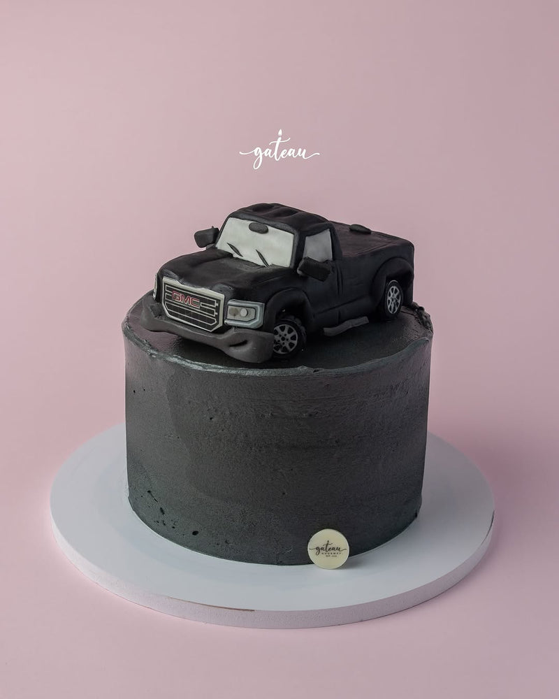 Unique birthday cakes for him featuring a chocolate truck design on a gray buttercream cake
