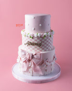 Melody-character-cake in pink with floral decorations and elegant bow from Gateau Gourmet Cafe