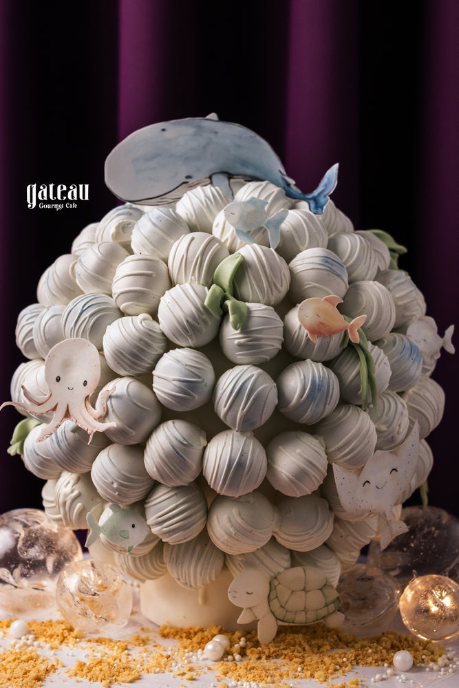 Gateau Gourmet Cafe whale truffle tower decorated with cute ocean-themed designs and colorful sea creatures