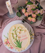 Elegant cake with floral cream design featuring a message of love and decorated flowers