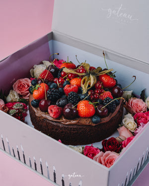 Gateau Gourmet Cafe chocolate fudge with mixed berries cake decorated with strawberries cherries and roses in a gift box