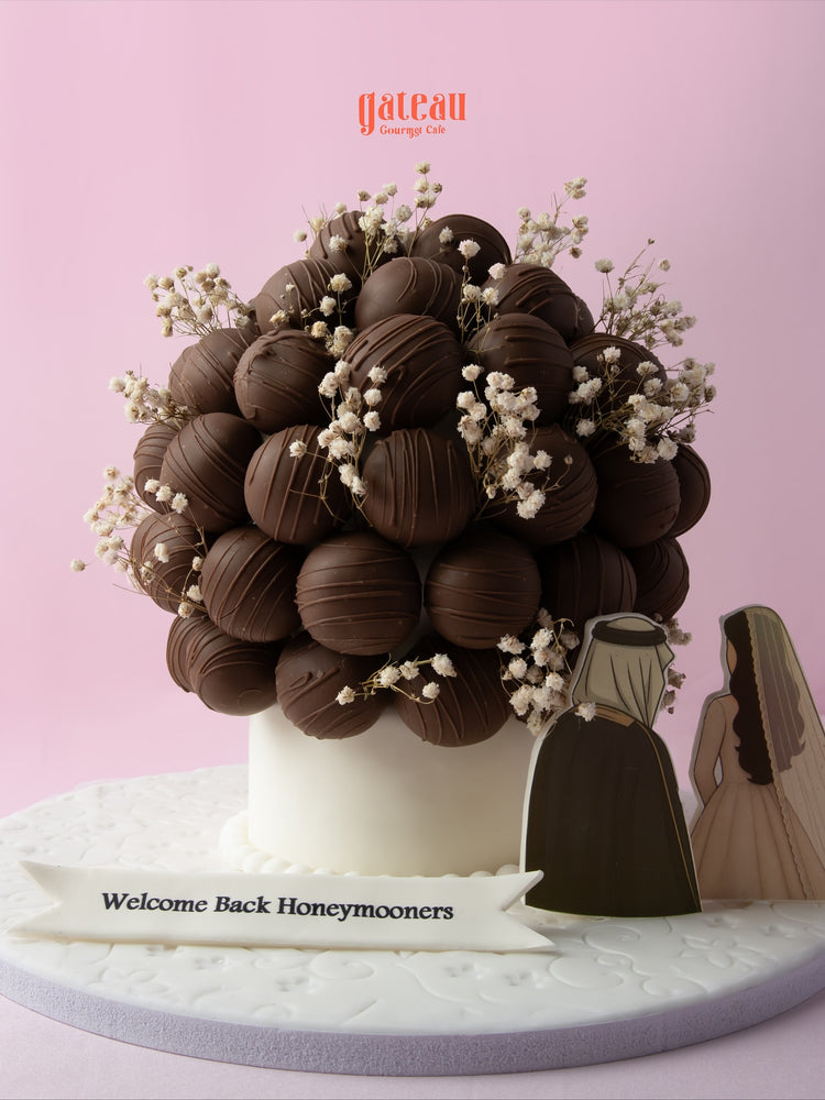 Chocolate truffle balls with flowers arranged in a decorative cake design for special celebrations