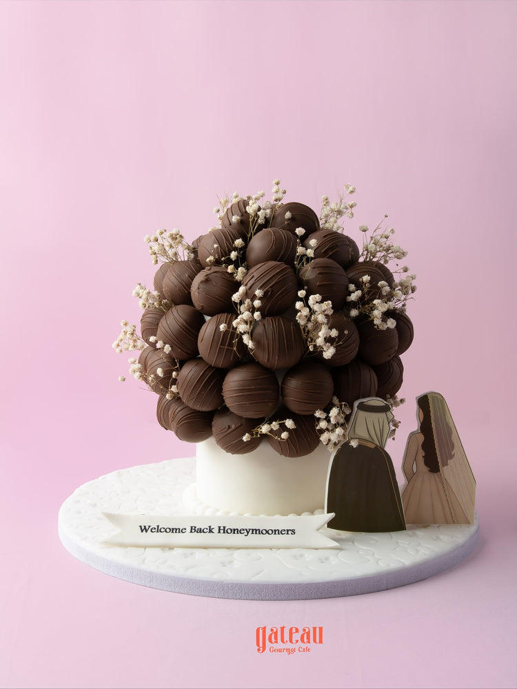 Chocolate truffle balls with flowers arranged in a decorative bouquet for a honeymoon celebration