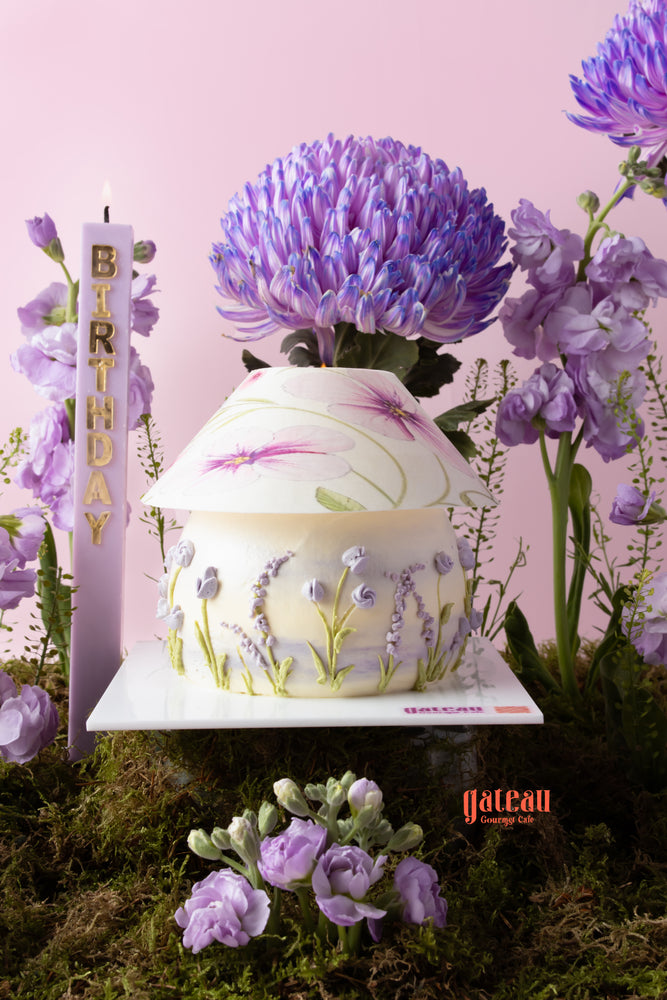 Beautiful chrysanthemum flower cake decorated with lavender blossoms and a candle for a birthday celebration