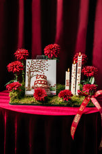 Classic mini cake arrangement by Gateau Gourmet Cafe with red flowers and candles on mossy base