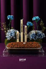 Crunch chocolate cake with flowers, featuring decorative candles and elegant floral arrangement