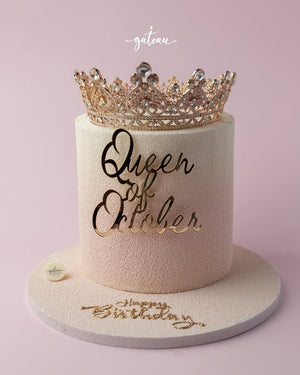 Elegant custom birthday cakes by Gateau Gourmet Cafe with gold Queen of October design and crown topper