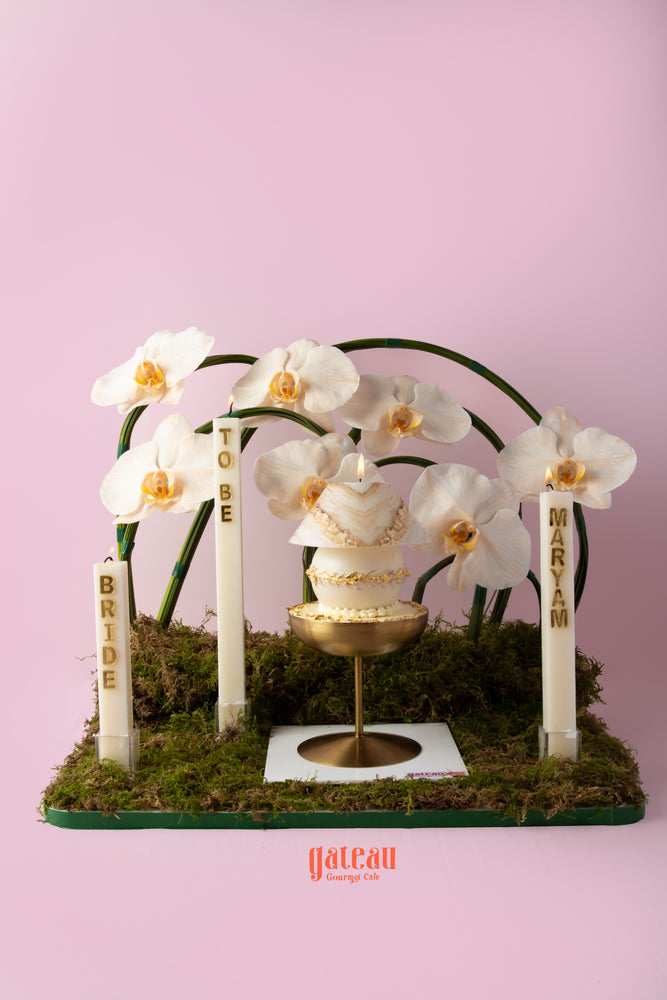 Elegant custom cake with flower arrangement featuring orchids for a bridal celebration at Gateau Gourmet Cafe