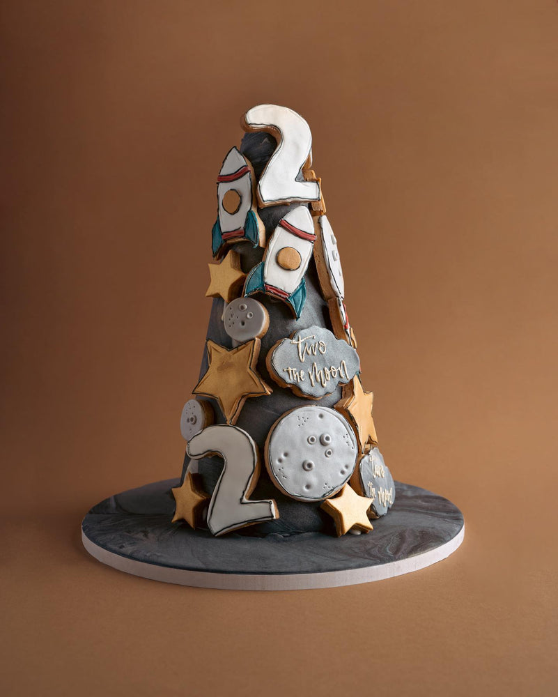 Gateau Gourmet Cafe custom decorated cookies arranged in a space-themed cone with rockets stars and numbers