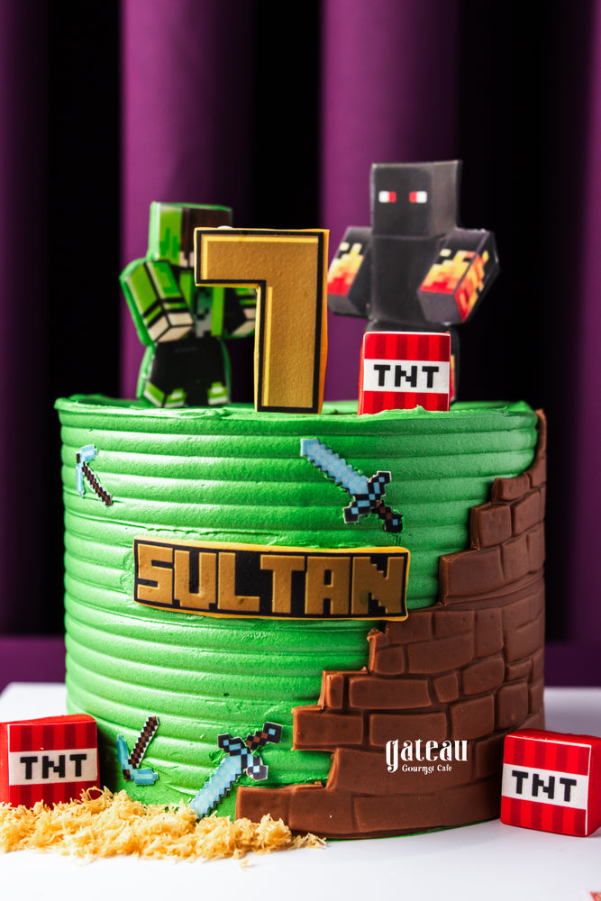 Custom Minecraft cake by Gateau Gourmet Cafe with green frosting, pixelated swords, TNT blocks, and character toppers