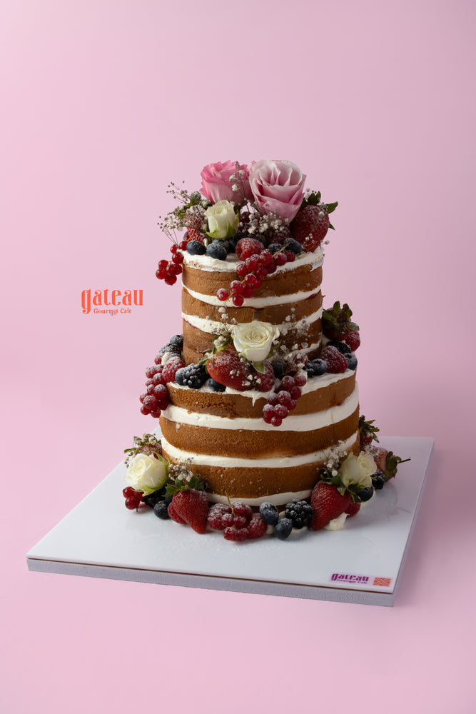 Beautiful custom naked cake with fresh fruit, decorated with roses and berries for special occasions