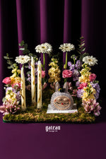 Customized graduation Labubu cake surrounded by flowers and decorative candles at Gateau Gourmet Cafe