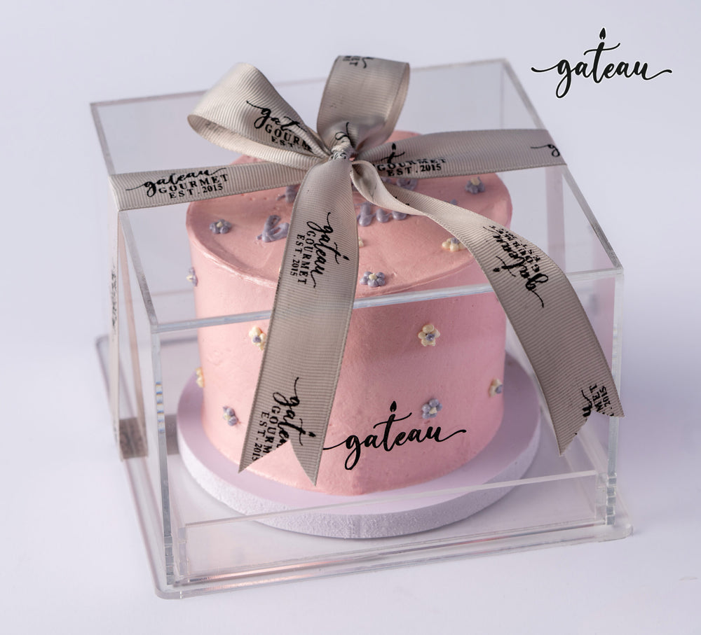Pink birthday cake for girls decorated with small flowers in clear gift box with ribbon from Gateau Gourmet Cafe
