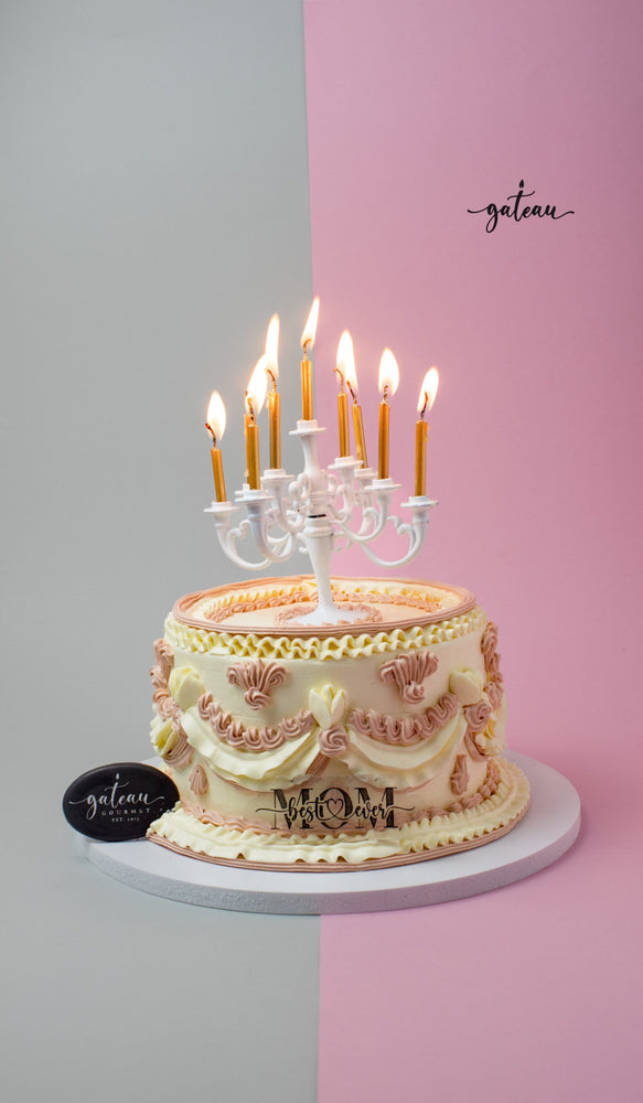 Decorative Mother's Day cake with elegant piped icing and lit candles from Gateau Gourmet Cafe