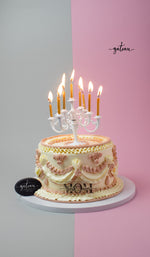 Decorative Mother's Day cake with elegant piped icing and lit candles from Gateau Gourmet Cafe