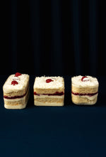 Three layered Coconut Fruit Treats with whipped cream, raspberries, and coconut topping from Gateau Gourmet Cafe
