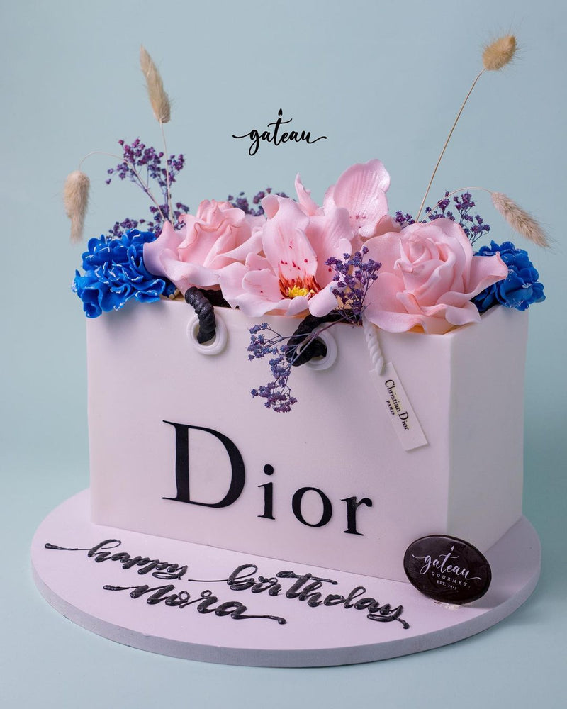 Dior gift cake from Gateau Gourmet Cafe, adorned with pink flowers and elegant details for special celebrations