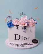 Dior gift cake by Gateau Gourmet Cafe decorated with flowers and a personalized message for a birthday