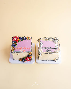 Gateau Gourmet Cafe mirror cake for special occasions decorated with colorful flowers and Elegant Women Day text