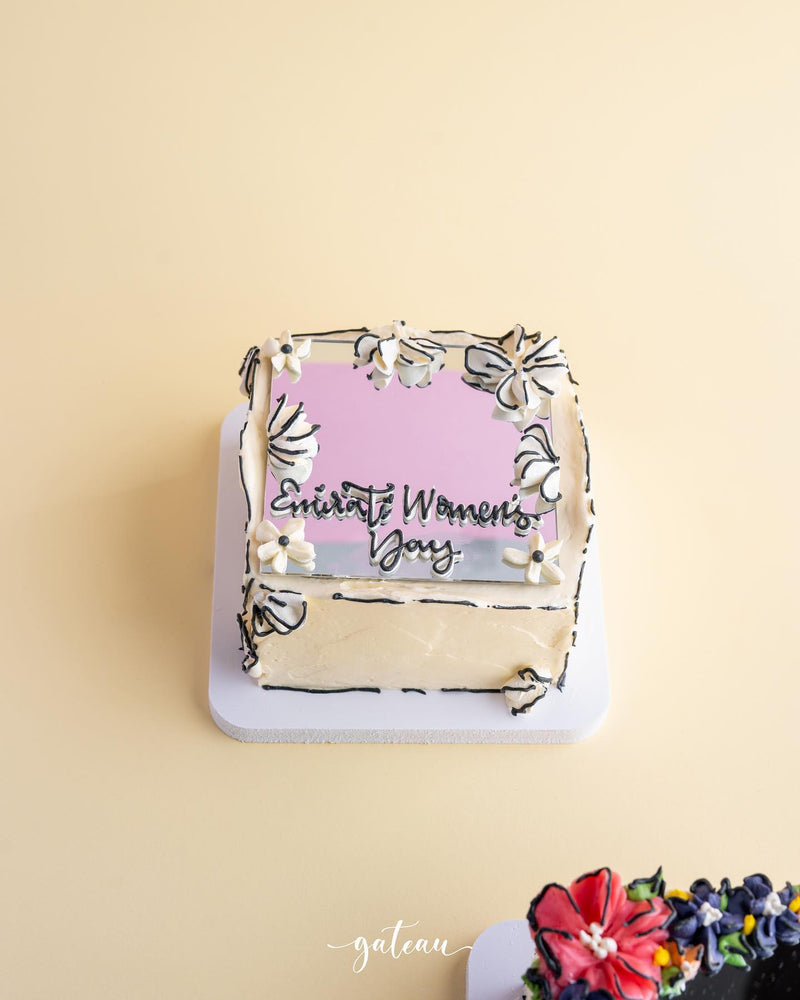 Gateau Gourmet Cafe mirror cake for special occasions with floral decorations and text on top