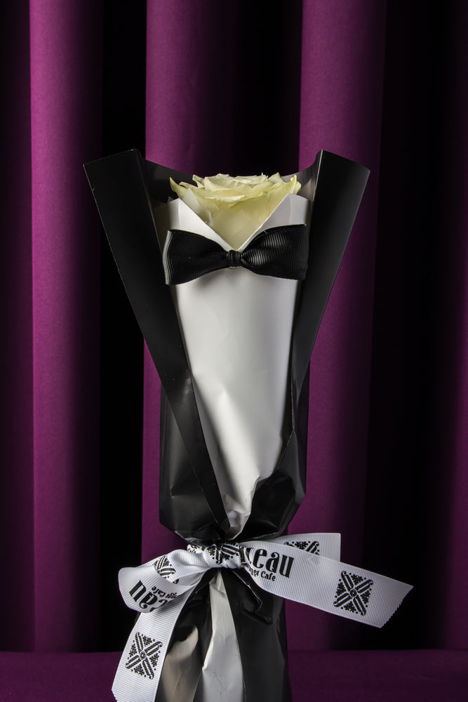 Father's Day flower from Gateau Gourmet Cafe featuring a white rose with black and white wrapping and bow