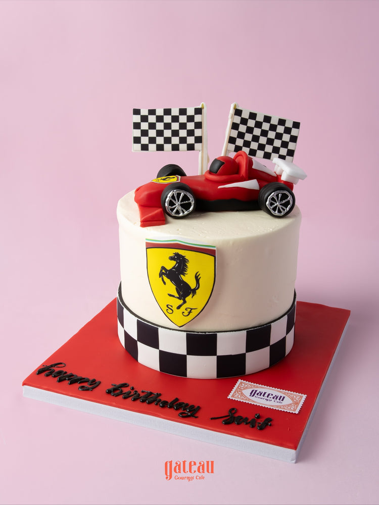 Ferrari theme cake with racing car topper and checkered flags for birthday celebrations