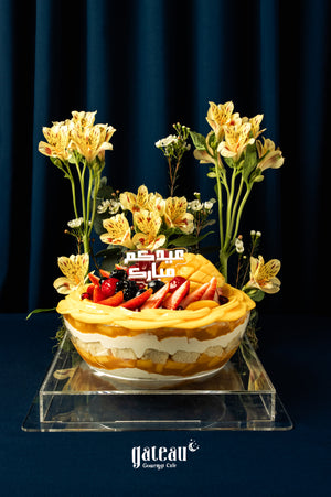Festive Eid dessert mango-fruit-bow topped with fresh fruits and edible flowers from Gateau Gourmet Cafe